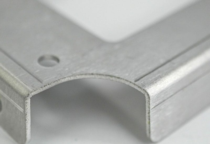 Close-up view of die marks leftover on a bent sheet metal part