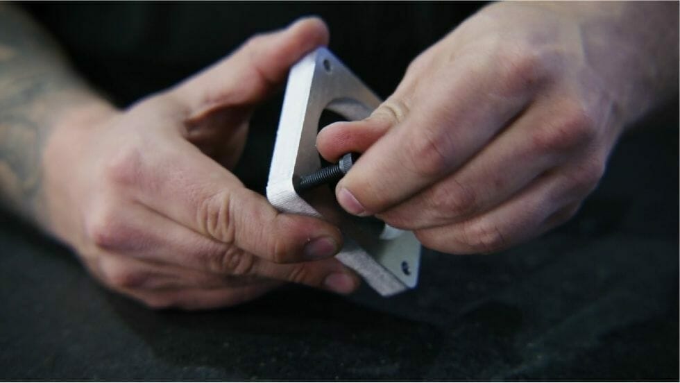 Screenshot from the video showing Jake threading a bolt into a tapped laser cut hole