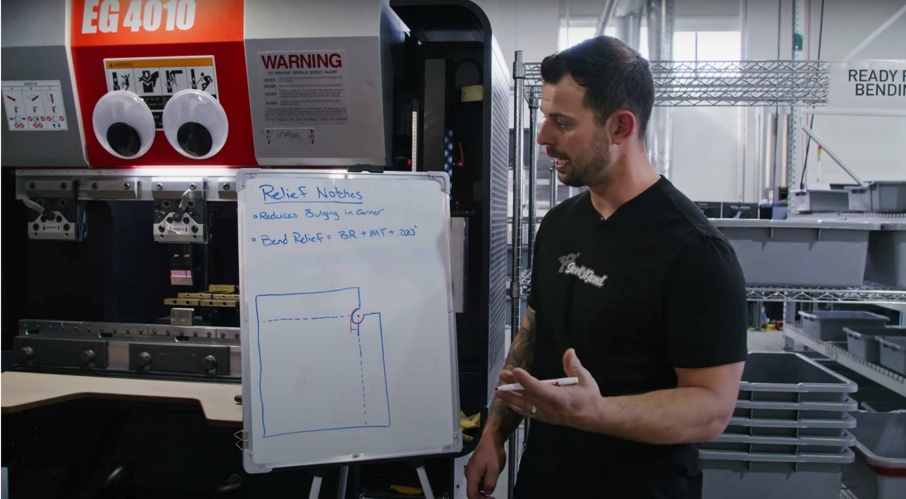 Screenshot from the video showing Jake next to a drawing that displays how to add relief notches to a bent sheet metal part