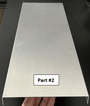 Image of a sheet metal aluminum part with 2 bends running perpendicular to the long plane, with text that reads "Part #2"