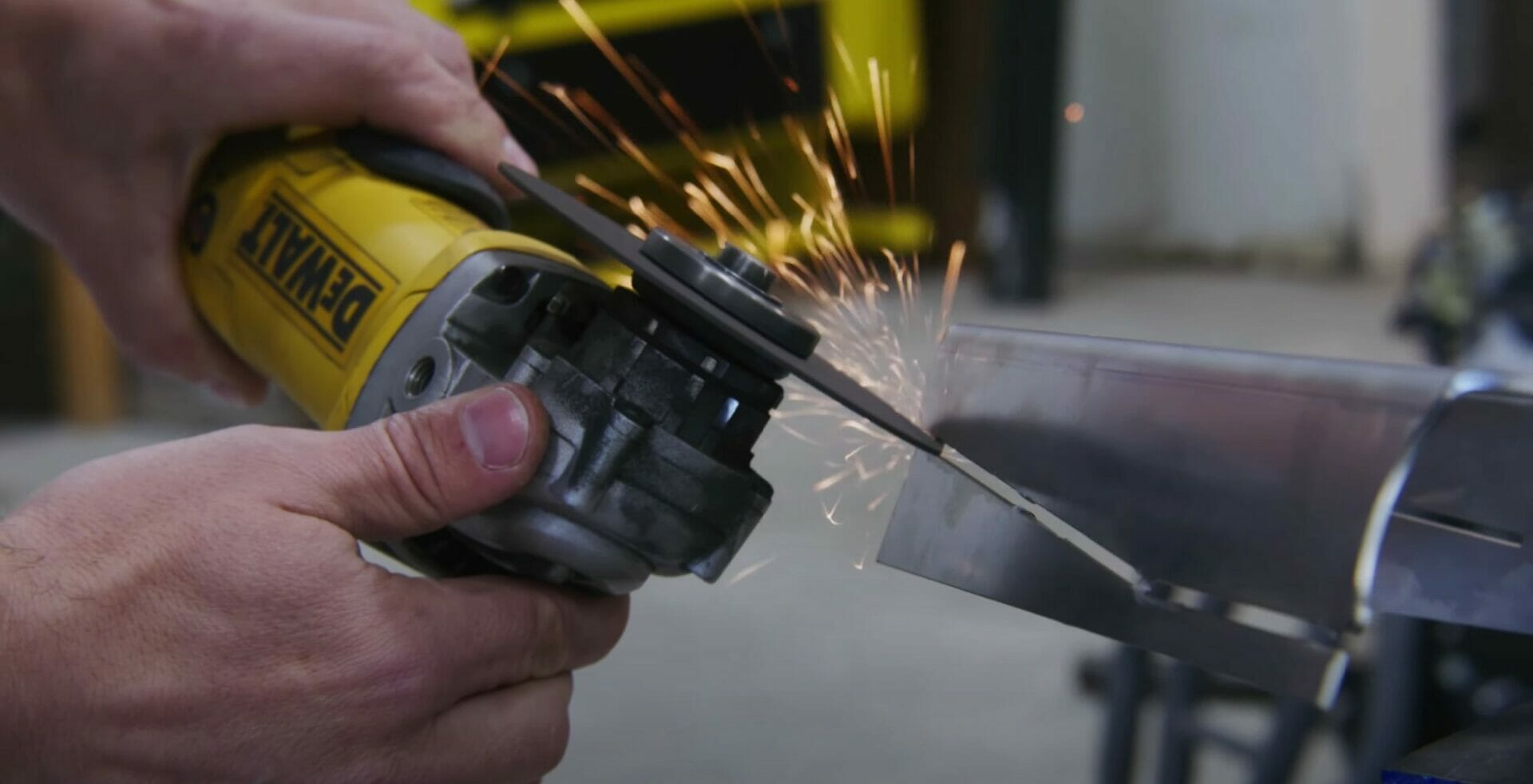 Jake uses an angle grinder to cut through the tabs on the irregular edge part, removing the faux parallel edge.